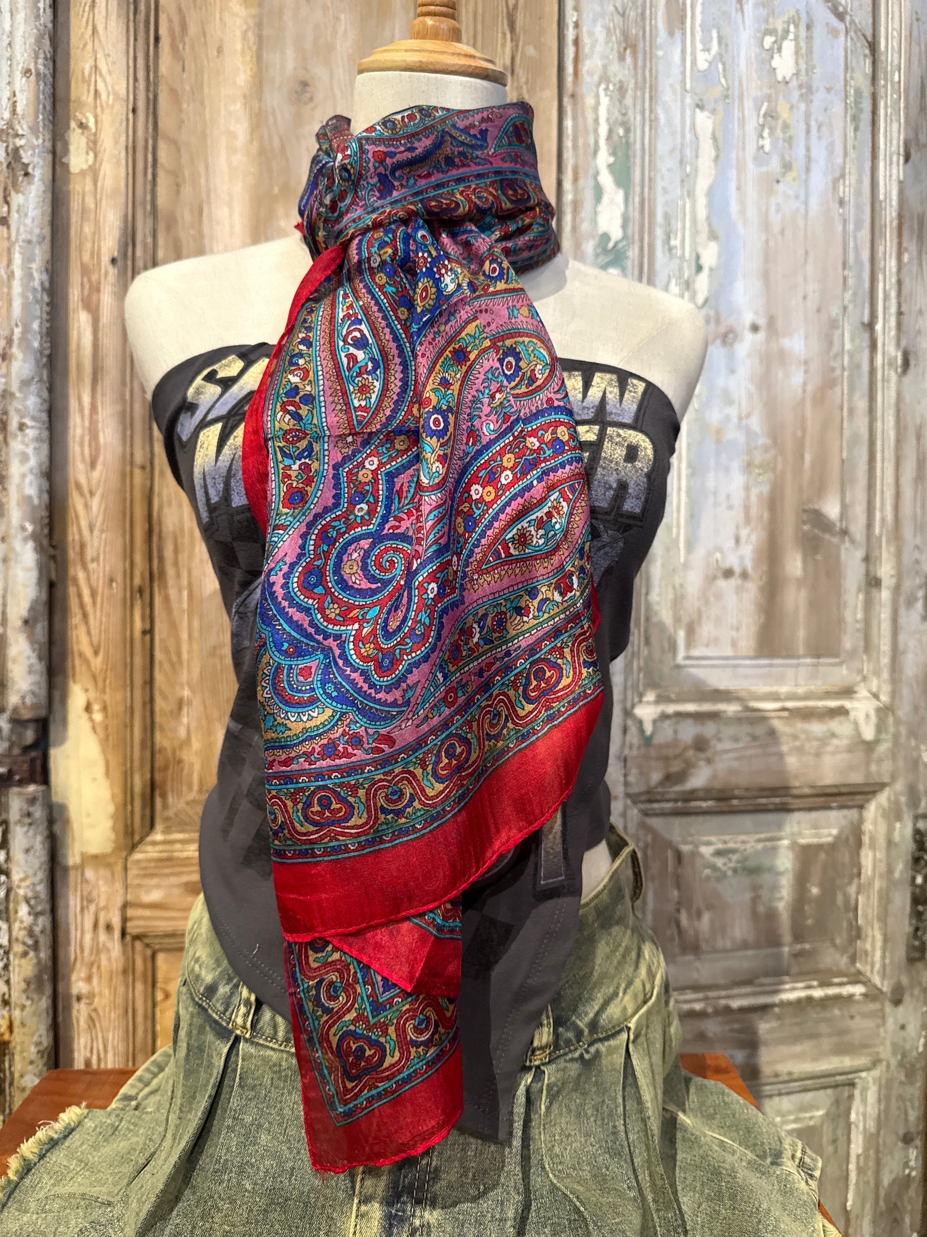 Trestles Clothing Company vibrant paisley silk boho scarf with red trim styled on a mannequin